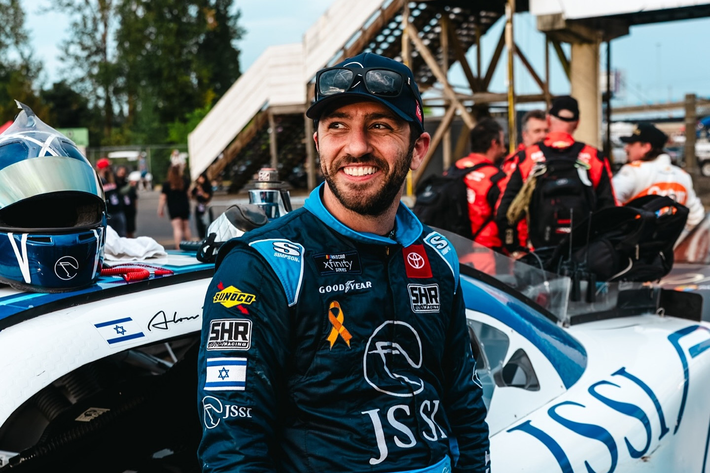 Alon Day smiles beside his #24 JSSI Toyota during the 2025 Pacific Office Automation 147 at Portland International Raceway