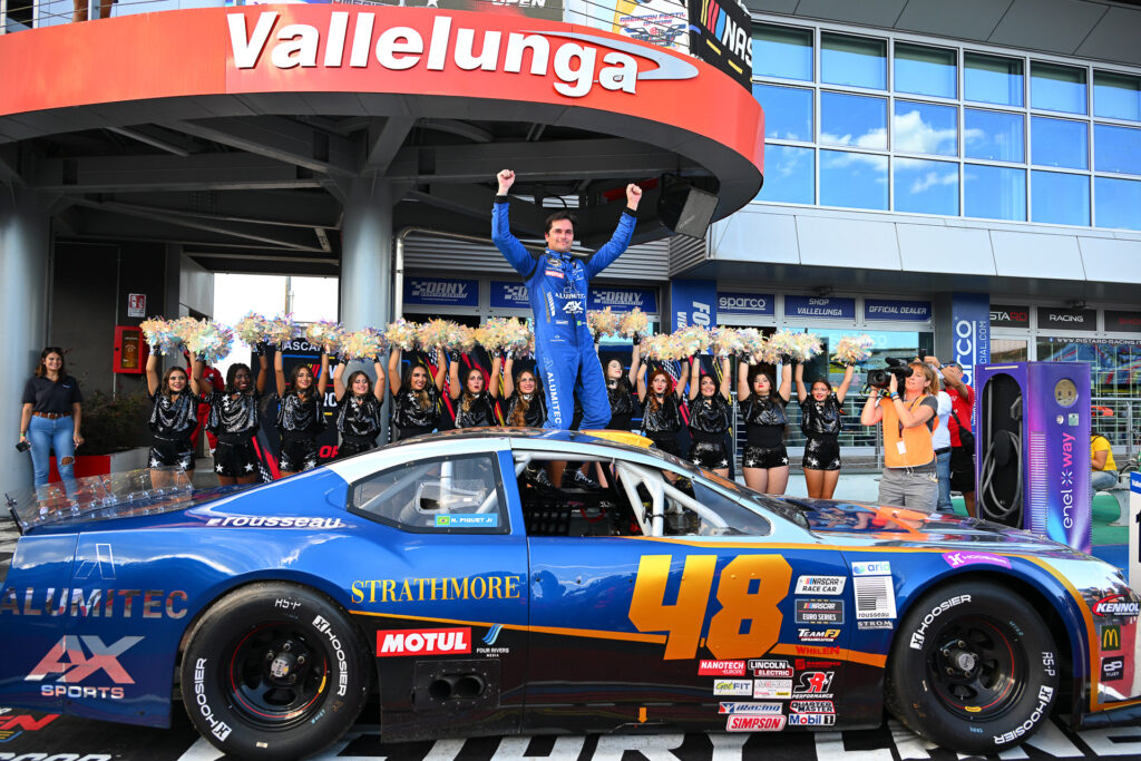 Nelson Piquet Jr. lifts his hands up to celebrate his maiden NASCAR Euro Series victory at Autodromo Vallelunga