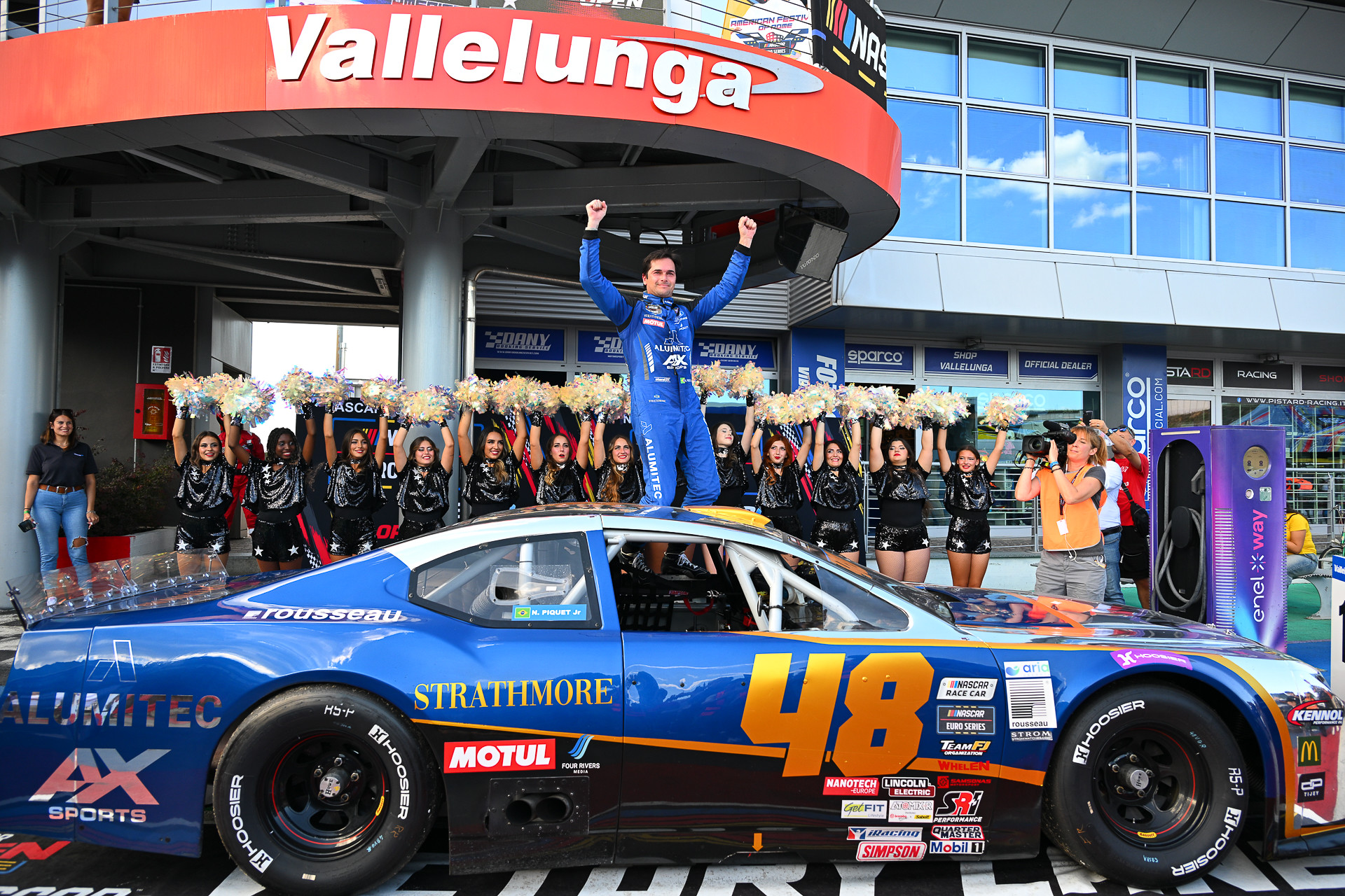 Nelson Piquet Jr. lifts his hands up to celebrate his maiden NASCAR Euro Series victory at Autodromo Vallelunga