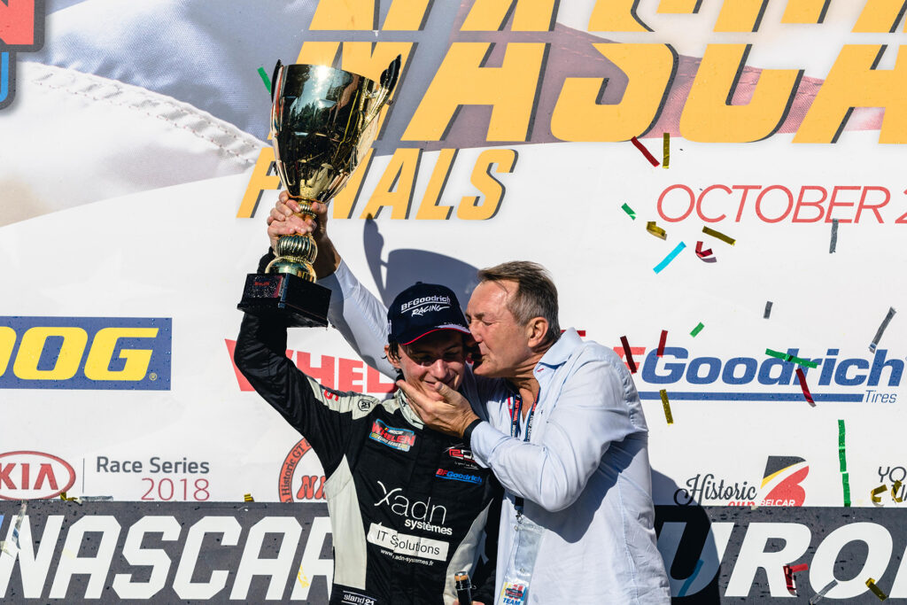 Ulysse Delsaux lifts the 2018 EuroNASCAR OPEN championship trophy, accompanied by his father Emmanuel