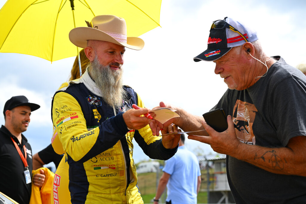 Claudio Remigio Cappelli gives a lucky Czech fan the opportunity to sign his memorabilia during the 2025 NASCAR GP Czech Republic