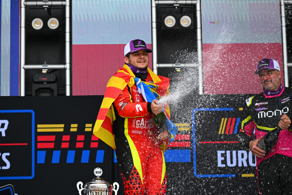 Paul Jouffreau sprays the champagne after his win in the 2025 Valencia NASCAR Fest with French racing legend Yvan Muller watching on