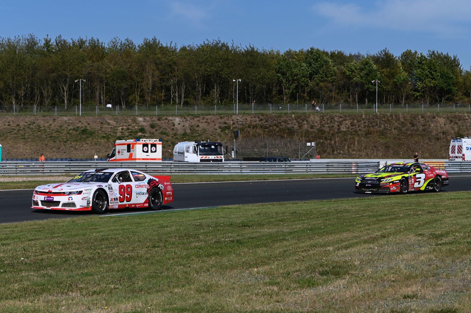 Bremotion's #99 Camaro and RDV Competition's #3 Ford races at Oschersleben during the 2025 NASCAR GP Germany