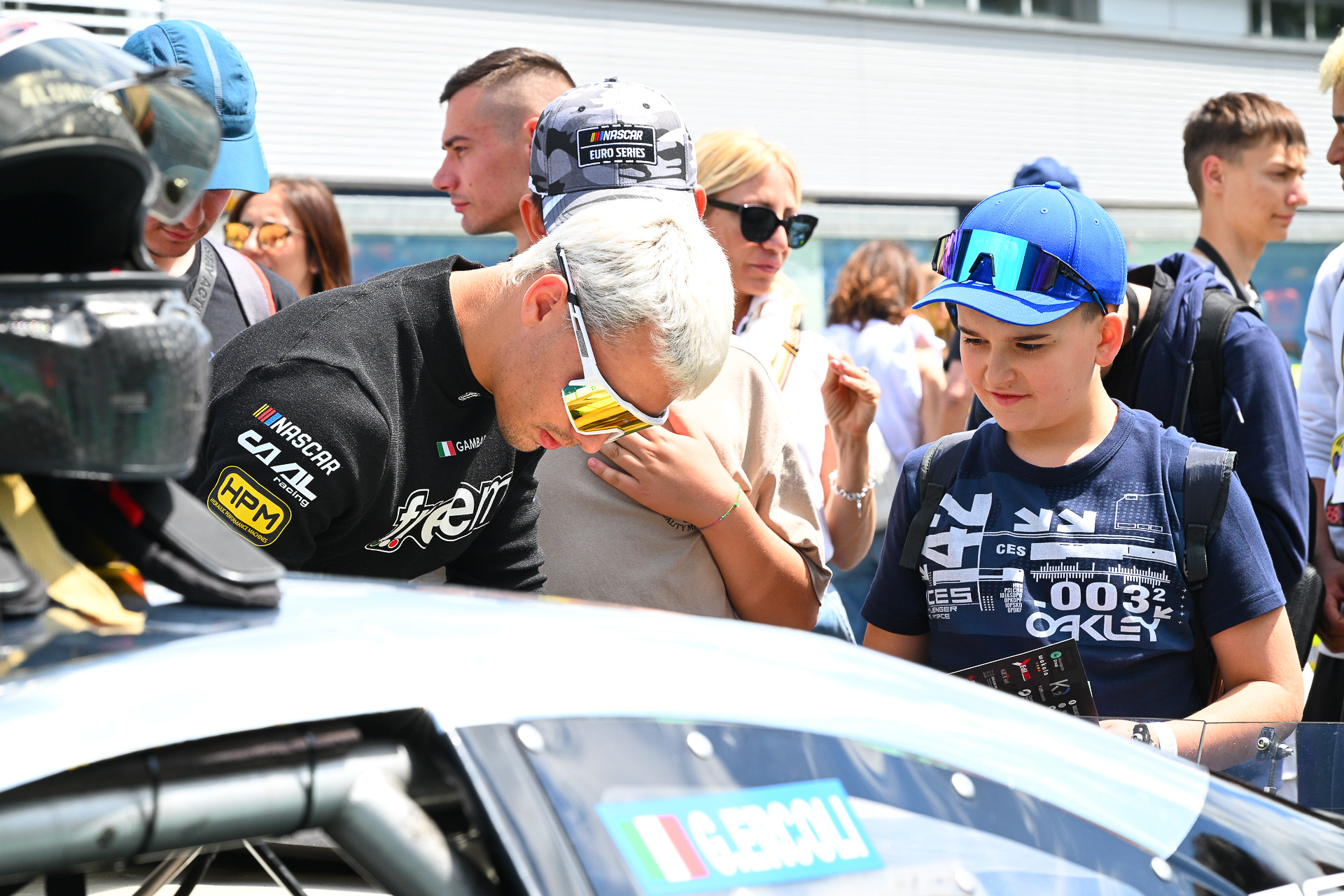 Valentino Gambarotto signs for a young fan during the 2025 NASCAR GP Italy at Vallelunga
