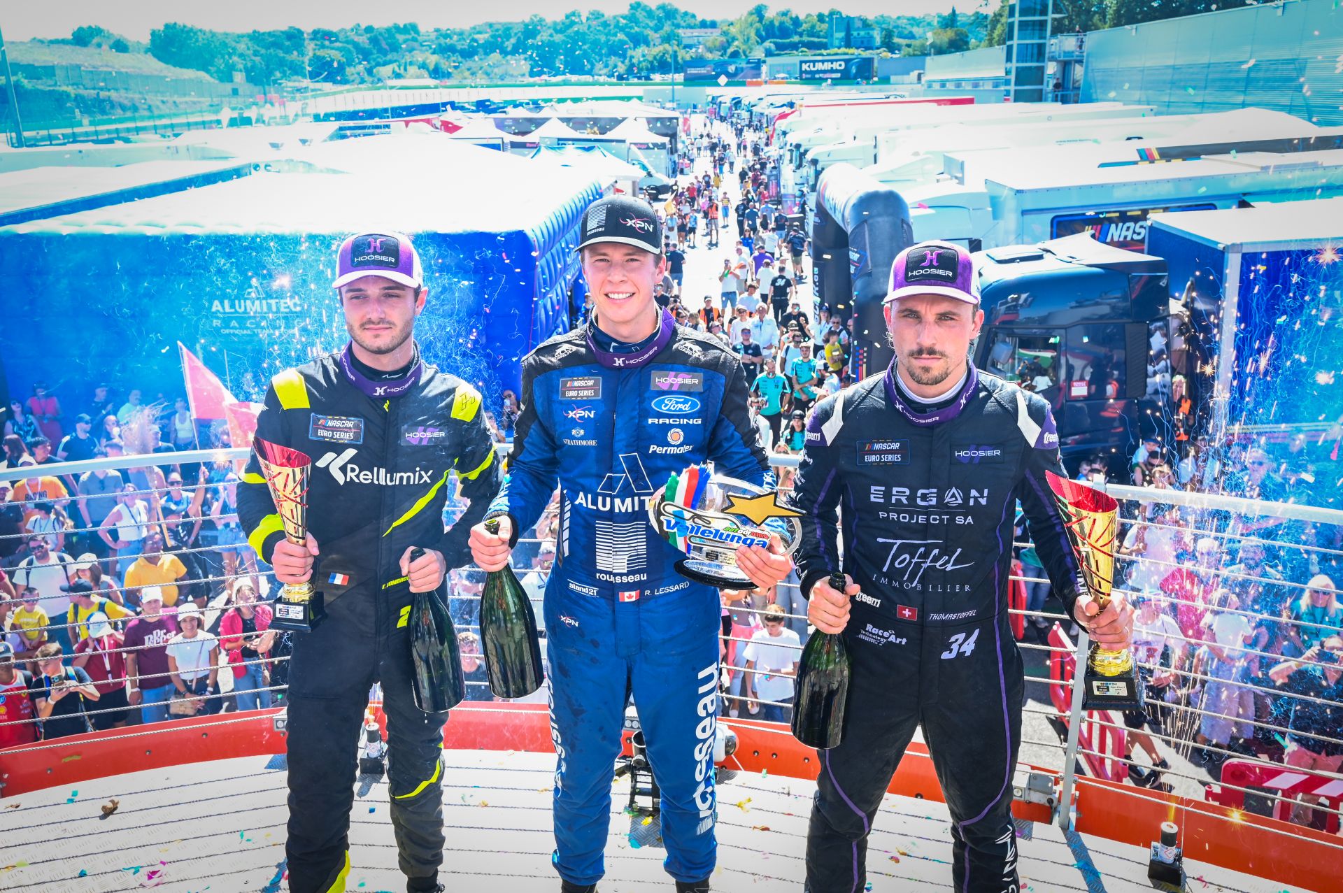 Raphaël Lessard celebrates his fifth EuroNASCAR OPEN win alongside Thomas Toffel (right), Thomas Dombrowski (left) and the Italian fans at Autodromo Vallelunga